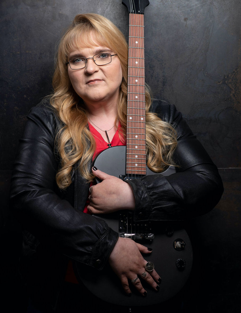 Whitney leaning against a railing on a downtown street